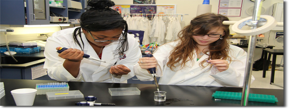 students wearing lab coats in a science classroom